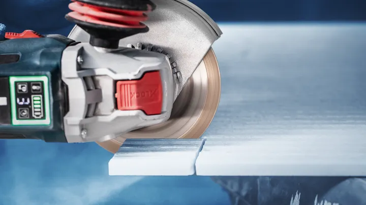 Circular saw cutting through a white tile slab.