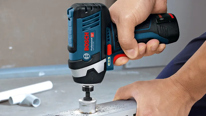 Person using a cordless impact driver to fasten a bolt into metal.