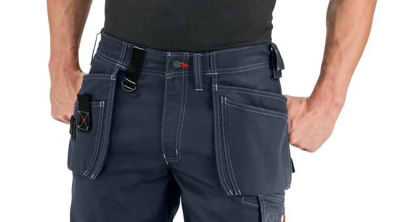 A person wearing blue work shorts with holster pockets and visible stitching.