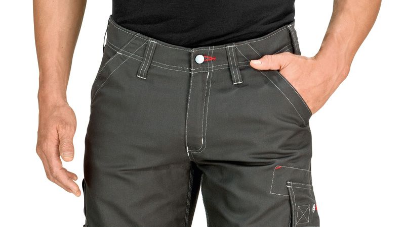 Person wearing grey work trousers with knee pockets and contrast stitching.