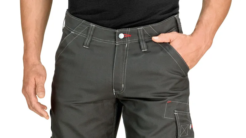 Person wearing grey work trousers with knee pockets and contrast stitching.