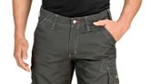Person wearing grey work trousers with knee pockets and contrast stitching.