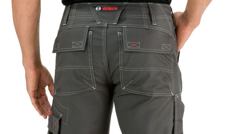 Person wearing grey work trousers with knee pockets, viewed from behind.