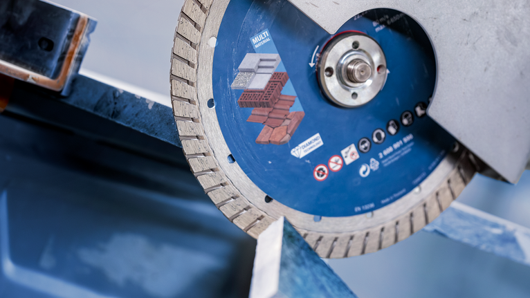 A diamond saw blade cuts through a concrete slab.