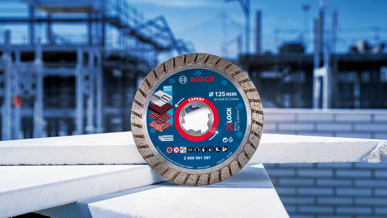Diamond saw blade placed on stacked construction materials at a building site.