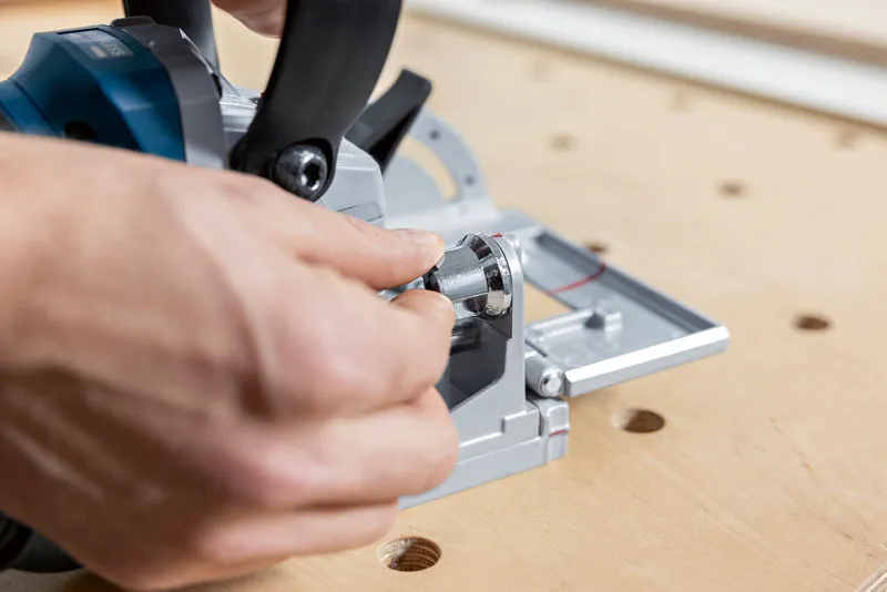 Person adjusting a biscuit joiner on a wooden workbench.