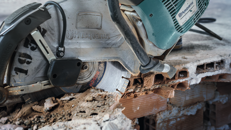 Power saw cutting through a concrete slab on a construction site.