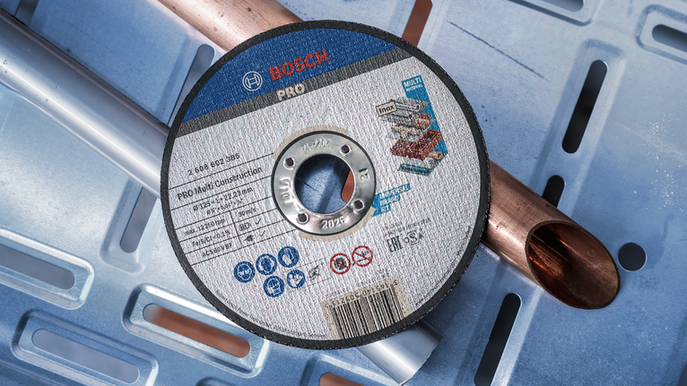 A cutting disc for multi-material use rests on metal pipes.
