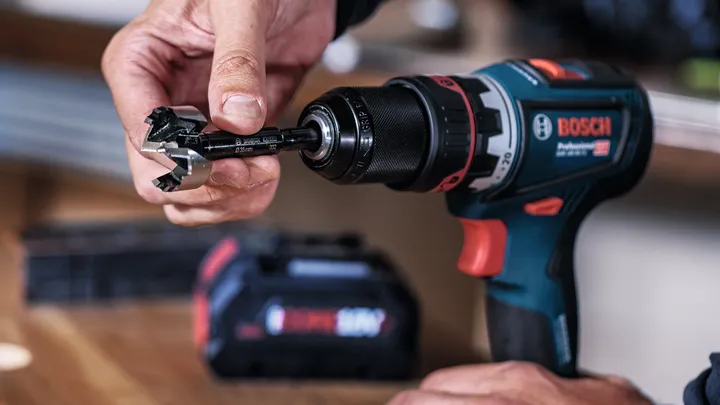 Person inserts a drill bit into a cordless power drill.