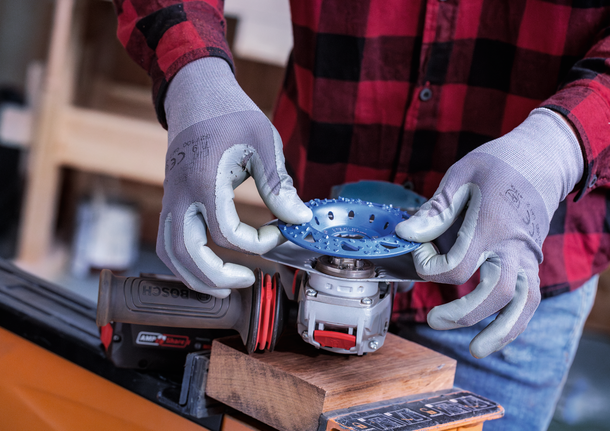 Person wearing safety equipment attaches a cutting disc to a power tool.
