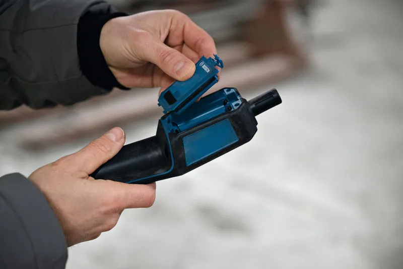 Person inserts a battery into a blue handheld tool.