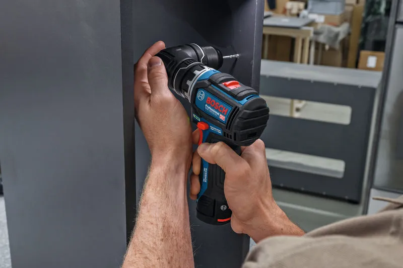 A person drills into a vertical metal surface using a cordless screwdriver.