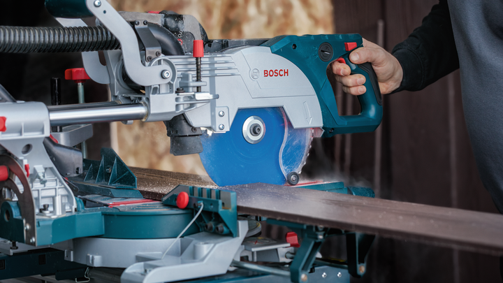 Person guiding a circular saw to cut a wooden board on a miter saw stand.