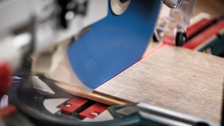 Circular saw cutting a wooden plank on a workbench.