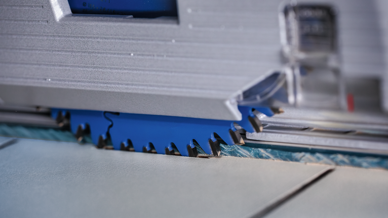 Circular saw blade cutting through a sheet of tile.