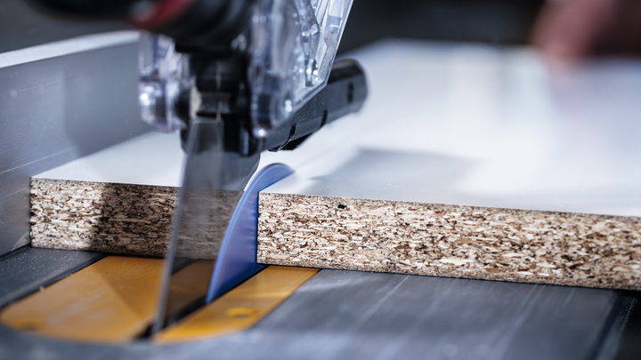 Circular saw cutting through a piece of particleboard.