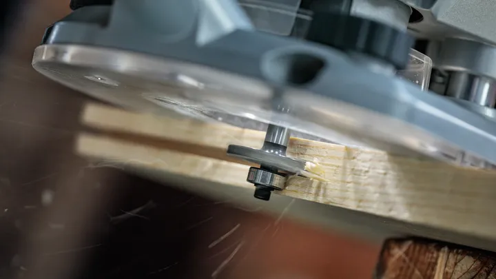 Router shaping the edge of a wooden board.
