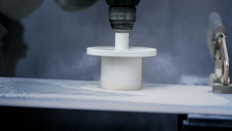 Hole saw attachment cutting a smooth circular opening in a flat surface.