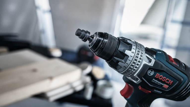 Power drill with a keyless chuck is positioned in a workshop.