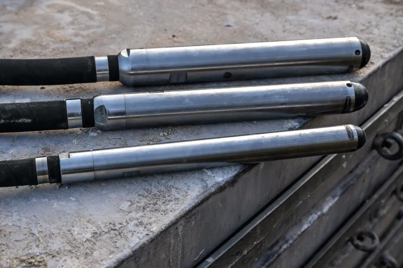 Three concrete vibrators rest on a construction surface.