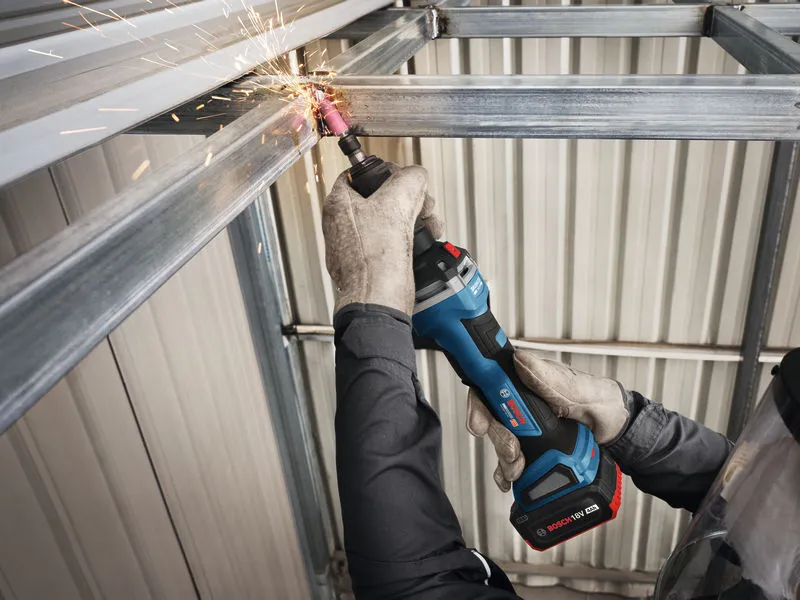 A person wearing safety equipment grinds a steel beam with a cordless straight grinder.