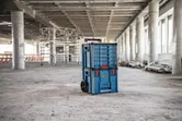 Rolling carrying case system with drawers stands in the middle of a construction site.