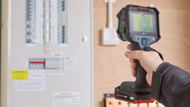 Person uses a thermo camera to scan an electrical panel.