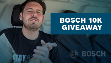 A man with short dark hair sits in a vehicle, gesturing with his hands, promoting the Bosch 10K Giveaway.