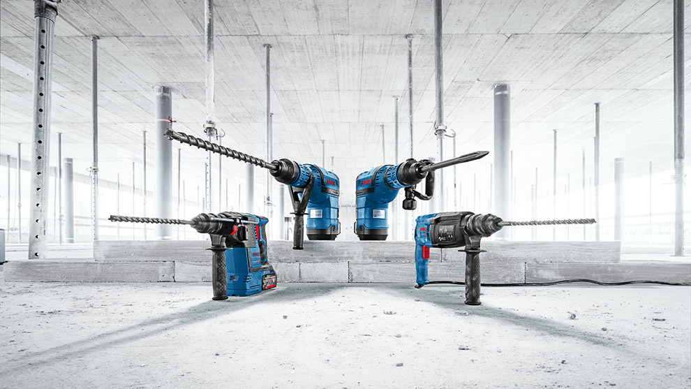 Four Bosch Professional power tools are arranged on a concrete floor in a bright space.