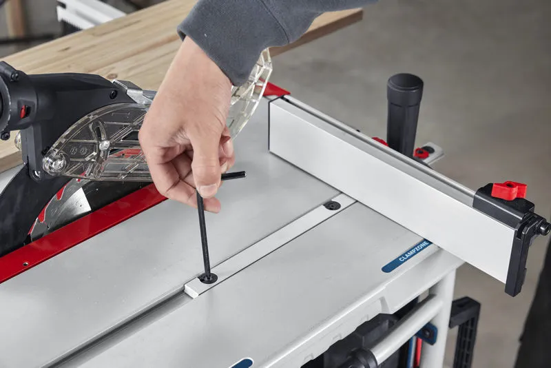 Person adjusts a table saw with an Allen key near a mounted guide rail.