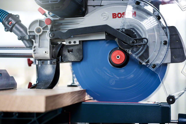 Mitre saw making a precise cut through a wooden board.