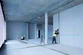 Construction workers using laser level.