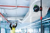 Worker installing ceiling framework.