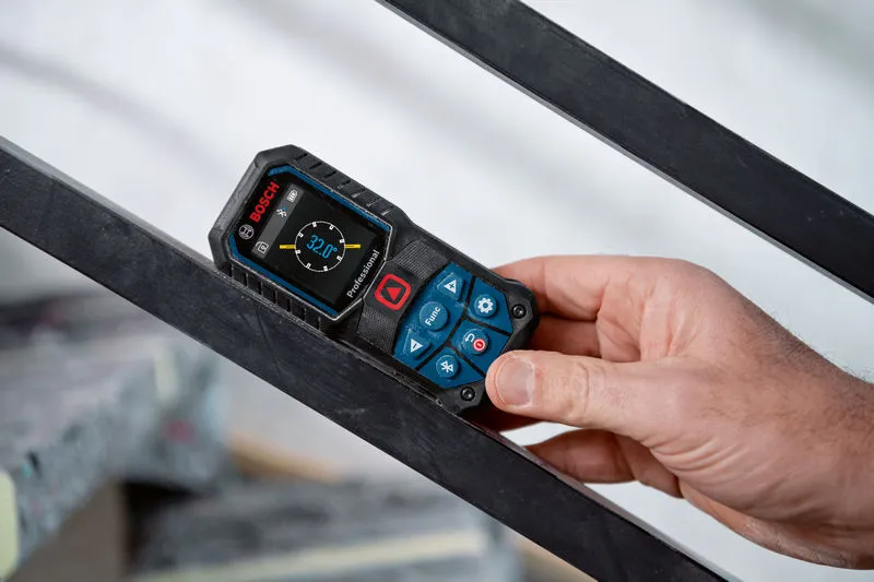 A person holds a laser measure against a metal railing.