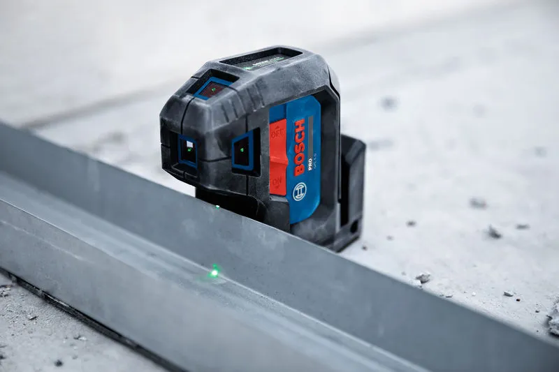 Laser leveling tool projecting green beams onto a metal guide for alignment.