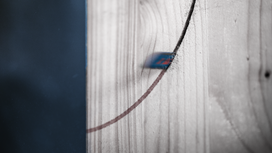 Reciprocating saw blade cutting a curved line into a wooden board.