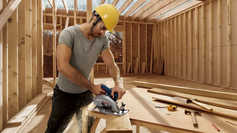 Man sawing wood construction.