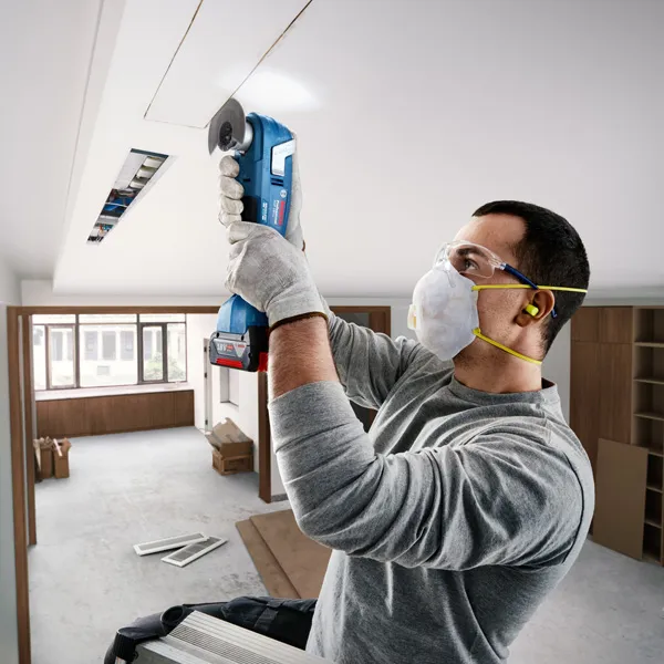 Bosch GOP 18V-28 multitool used for ceiling cutting.