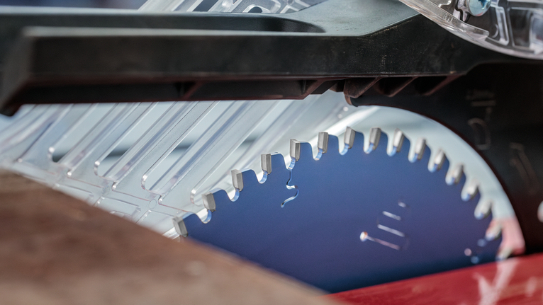 Circular saw blade positioned beneath a transparent safety guard.