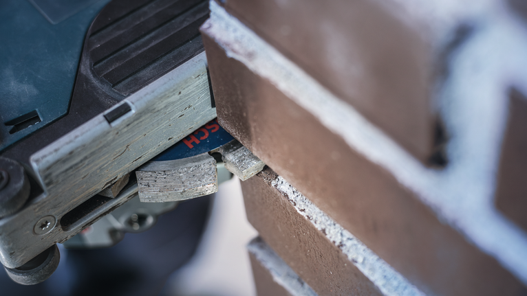 Γωνιακός τροχός με διαμαντένια λεπίδα που κόβει αυλακώσεις σε κονίαμα τούβλων.