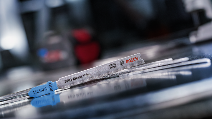 Μεταλλικές λεπίδες παζλ που βρίσκονται σε μια ανακλαστική μεταλλική επιφάνεια σε ένα εργαστήριο.