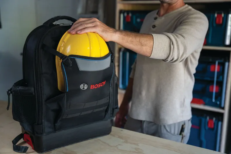 Σακίδιο πλάτης Bosch L-BOXX Contractor που κρατάει ένα κίτρινο σκληρό κράνος.