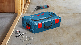 Μια μπλε εργαλειοθήκη Bosch Professional στο πάτωμα με εργαλεία γύρω της.