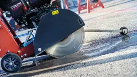 Pila za beton reže mokri pločnik na gradilištu.