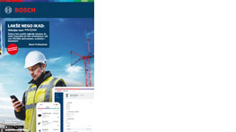 Čovjek u radnoj odjeći i kacigi koristi telefon na gradilištu.