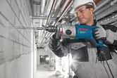 Elektromos ütvefúró kiegészítő fogantyúval és hosszú kőzetfúróval.