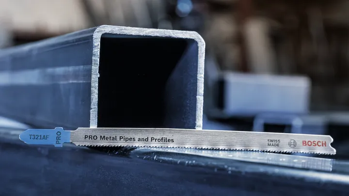 Fűrészlap fémcsövek és profilok vágásához, fémcsatorna mellé helyezve.