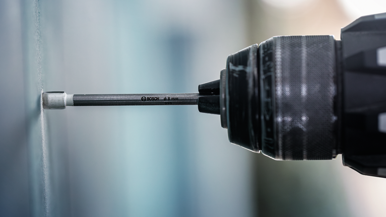 Egy fúrófejet a falba ütő elektromos fúró.