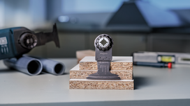 להב כלי מתנדנד מוצג על גבי לוחות חלקיקים מוערמים בסדנה.