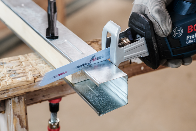 Person wearing safety equipment uses a reciprocating saw to cut a metal channel.